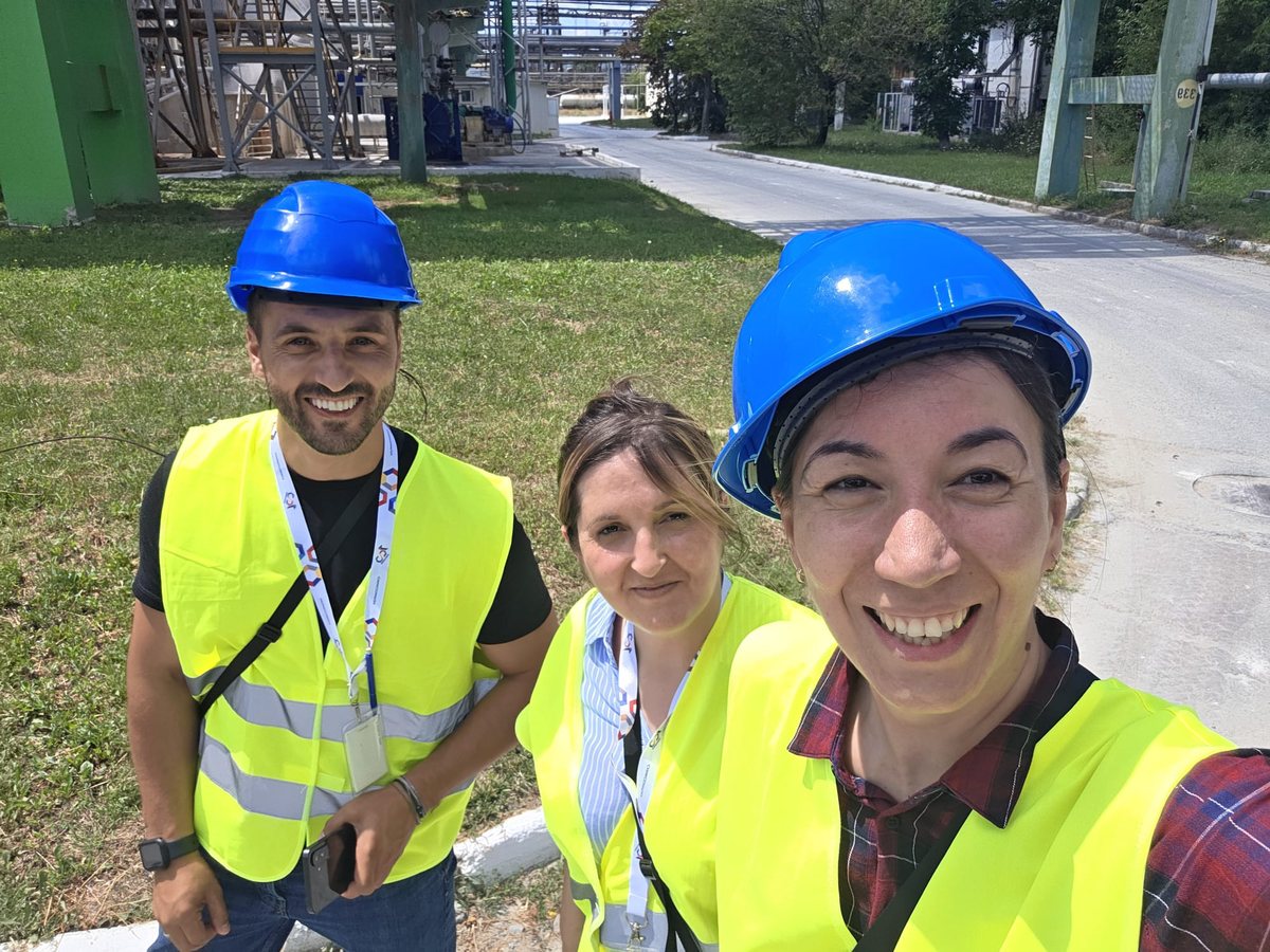 Three GIS consultants, in hard hats and high-visibility vests, visiting an industrial site